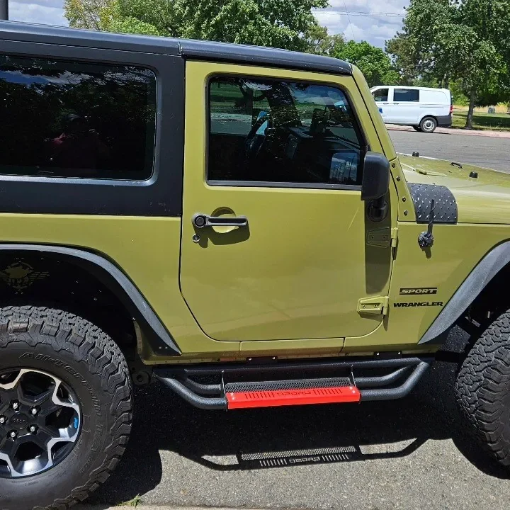 Green Jeep Wrangler with freshly tinted windows, parked in front of King Window Tint at 2450 Fulton Ave, Sacramento (two-door)