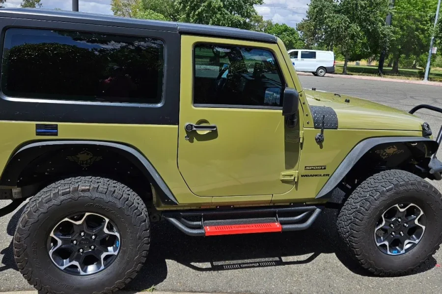 Green Jeep Wrangler with freshly tinted windows, parked in front of King Window Tint at 2450 Fulton Ave, Sacramento (two-door)