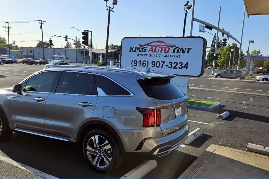 Silver Kia Sorento with freshly tinted windows, parked in front of King Auto Tint at 2450 Fulton Ave, Sacramento