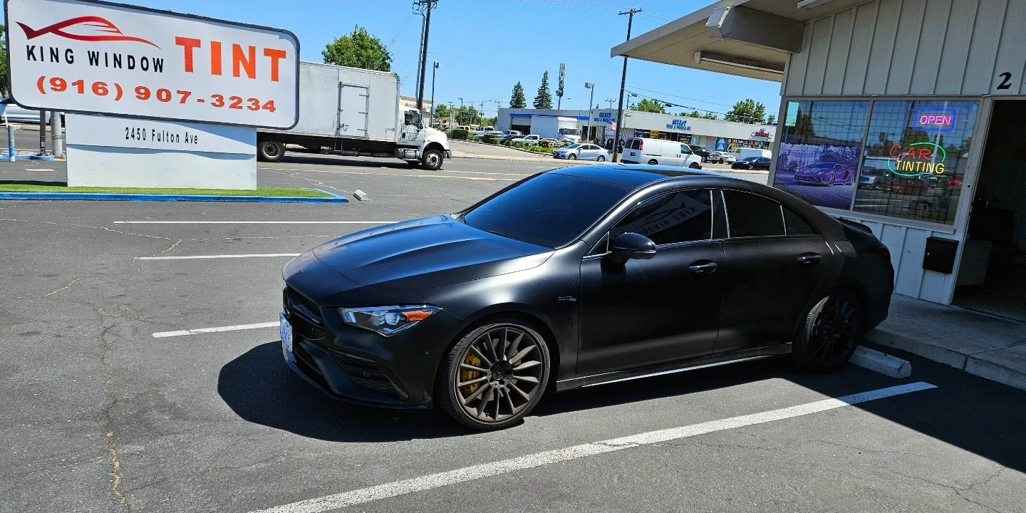 Matte black Mercedes-AMG CLA 45 with freshly tinted windows, outside the King Window Tint shop on Fulton Ave in Sacramento