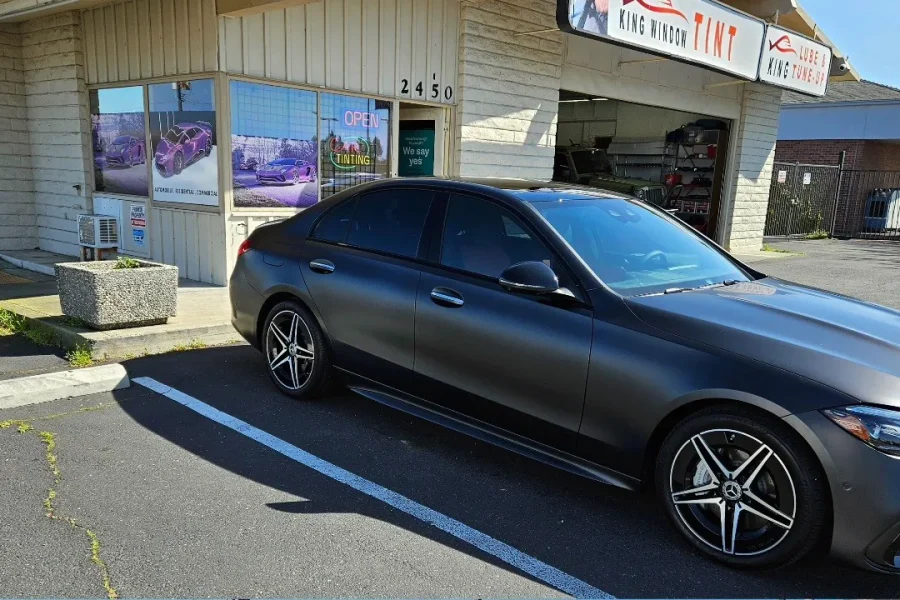 Matte gray Mercedes-Benz C-Class with freshly tinted windows, outside the King Window Tint shop on Fulton Ave in Sacramento