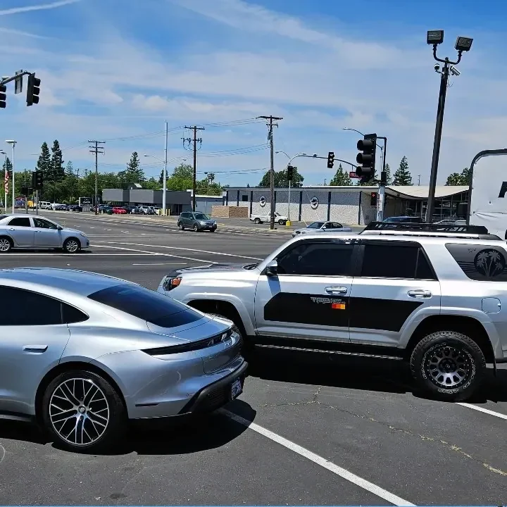 Silver Porsche Taycan with freshly tinted windows, photographed after its tint job at King Auto Tint in Sacramento (shown with a Toyota 4Runner)