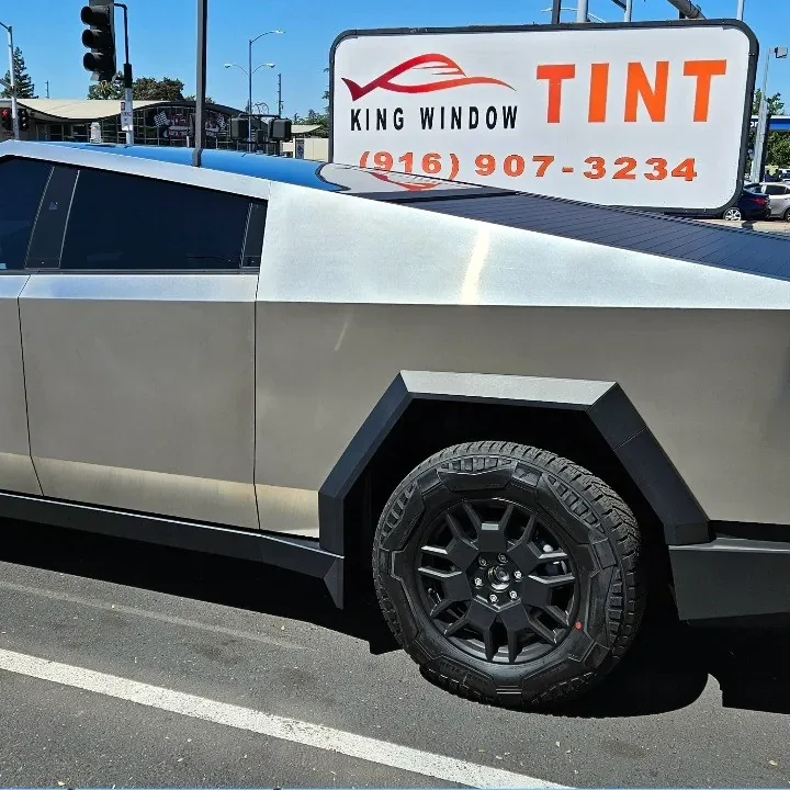 Stainless steel Tesla Cybertruck with freshly tinted windows, outside the King Window Tint shop on Fulton Ave in Sacramento