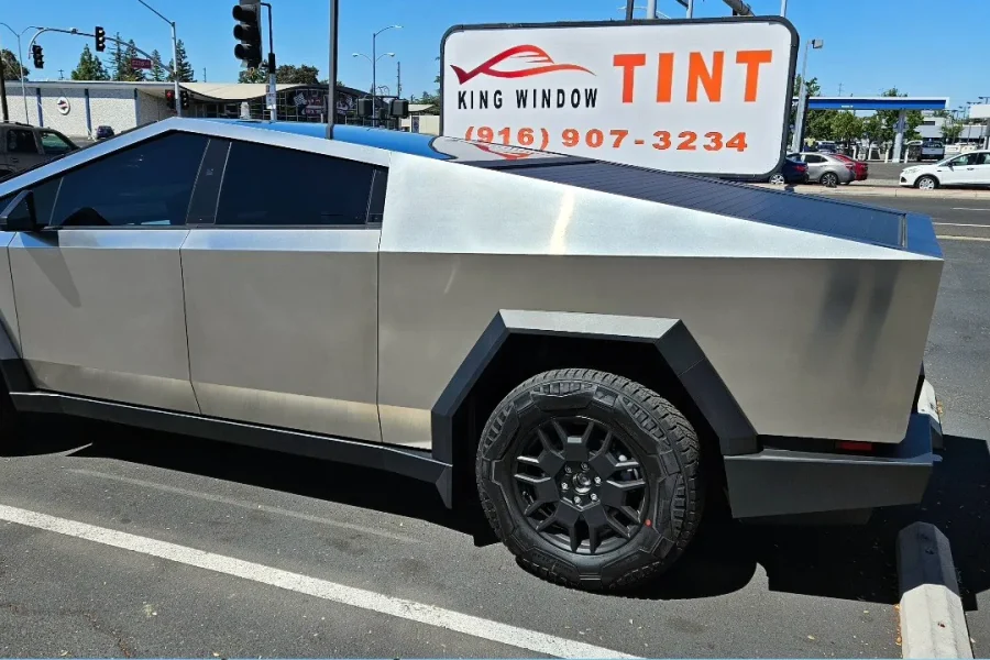 Stainless steel Tesla Cybertruck with freshly tinted windows, outside the King Window Tint shop on Fulton Ave in Sacramento