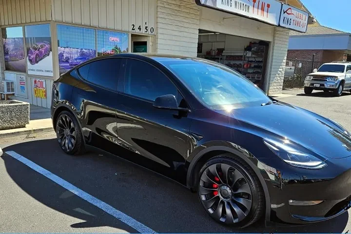 Black Tesla Model Y Performance with freshly tinted windows, outside the King Window Tint shop on Fulton Ave in Sacramento