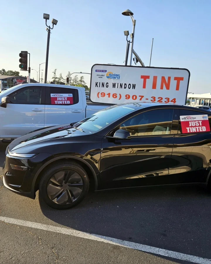 Black Tesla Model Y with freshly tinted windows, parked in front of King Window Tint at 2450 Fulton Ave, Sacramento (with a Just Tinted sign)