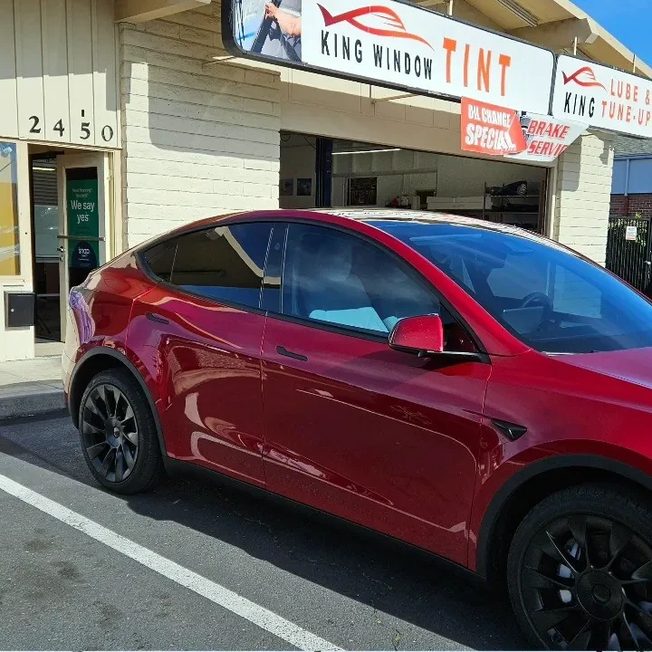 Red Tesla Model Y with freshly tinted windows, outside the King Window Tint shop on Fulton Ave in Sacramento