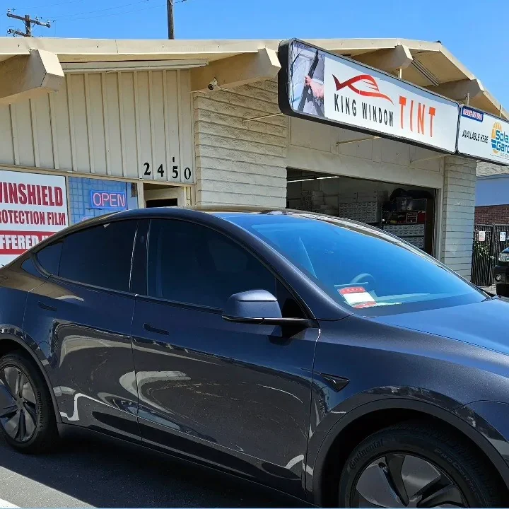 Gray Tesla Model Y with freshly tinted windows, outside the King Window Tint shop on Fulton Ave in Sacramento
