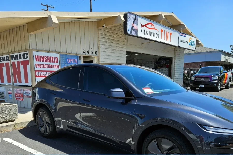 Gray Tesla Model Y with freshly tinted windows, outside the King Window Tint shop on Fulton Ave in Sacramento