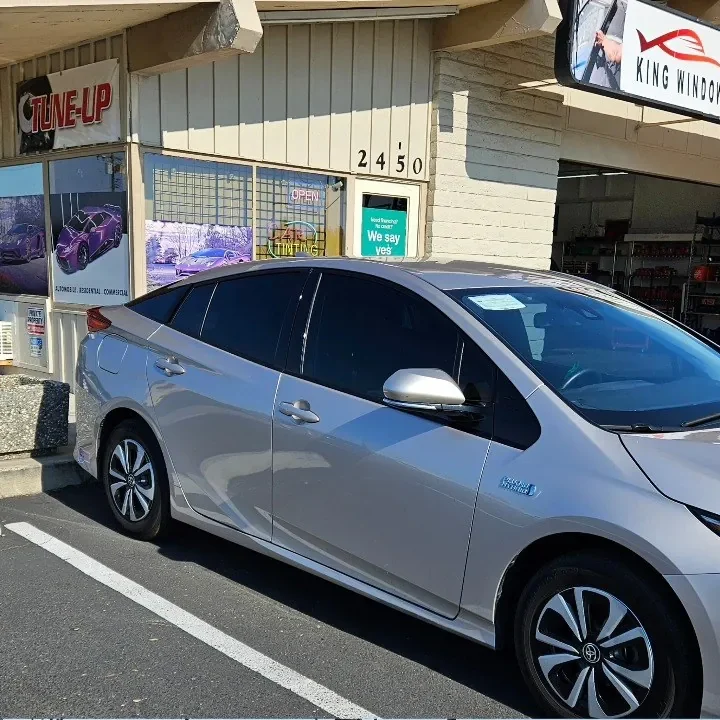 Silver Toyota Prius Prime with freshly tinted windows, outside the King Window Tint shop on Fulton Ave in Sacramento