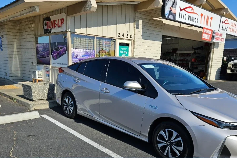 Silver Toyota Prius Prime with freshly tinted windows, outside the King Window Tint shop on Fulton Ave in Sacramento