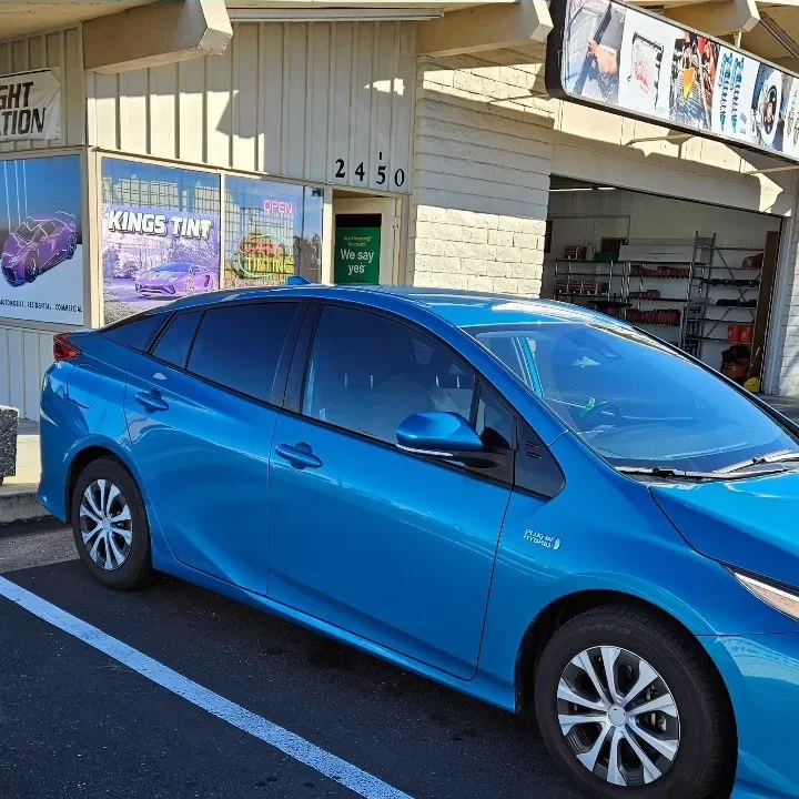Blue Toyota Prius Prime with freshly tinted windows, outside the King Auto Tint shop on Fulton Ave in Sacramento