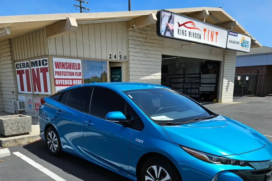 Blue Toyota Prius Prime with freshly tinted windows, in the King Window Tint parking lot on Fulton Avenue, Sacramento