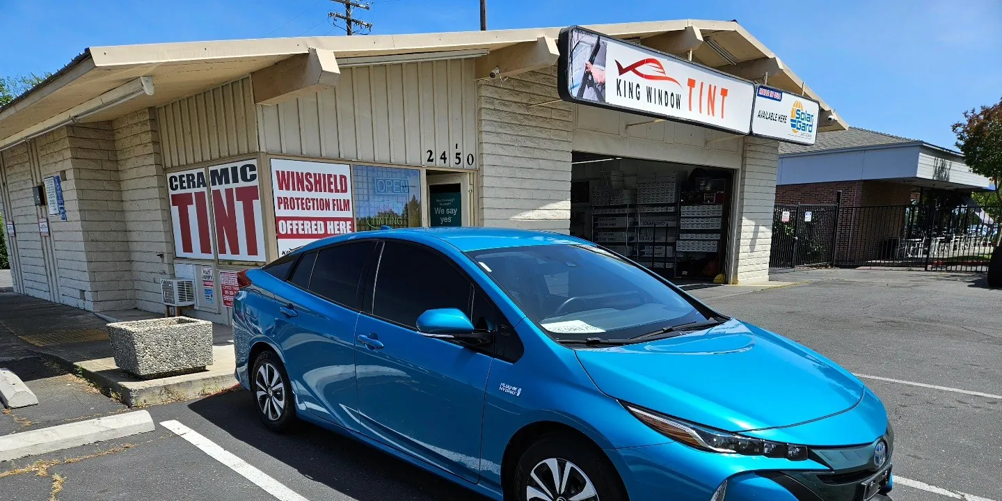 Blue Toyota Prius Prime with freshly tinted windows, in the King Window Tint parking lot on Fulton Avenue, Sacramento