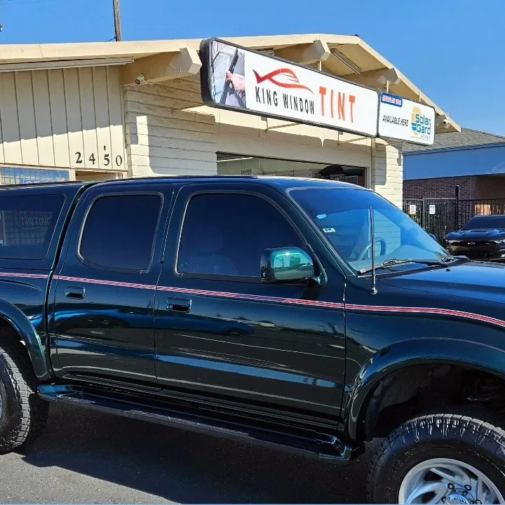 Dark green Toyota Tacoma with freshly tinted windows, in the King Window Tint parking lot on Fulton Avenue, Sacramento (first generation)