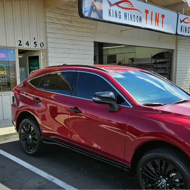 Red Toyota Venza with freshly tinted windows, beside the King Window Tint sign on Fulton Ave, Sacramento